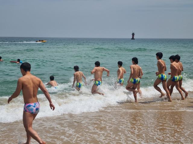 지난 12일 강원도 강릉시 경포해변을 찾은 수상안전요원들이 훈련을 위해 바다에 입수하고 있다. 뉴스1