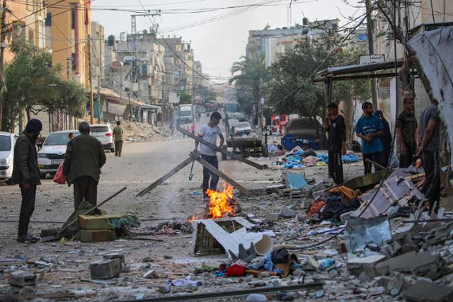 팔레스타인 피란민들이 20일 가자지구 남부 라파에서 전날 밤 이스라엘 폭격으로 무너진 가정집 잔해에서 물건을 수습하고 있다. 라파=AFP 연합뉴스
