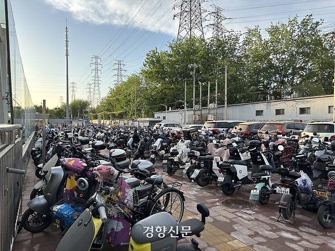 베이징 외곽의 한 지하철역 앞에 배달과 차량호출 서비스 등에 이용되는 오토바이와 승용차가 줄지어 주차돼 있다. 2024년 4월 촬영/박은하 기자