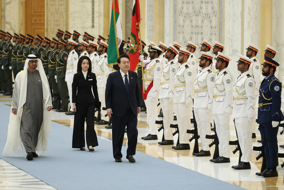 President Yoon Suk Yeol, right, and United Arab Emirates (UAE) President Mohammed bin Zayed Al Nahyan, left, accompanied by first lady Kim Keon Hee, center, view an honor guard during an official welcome ceremony during their bilateral summit on Jan. 15 in Abu Dhabi. [JOINT PRESS CORPS]