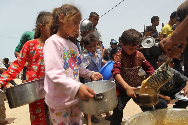 19일(현지시각) 가자지구 남부 도시 라파에서 팔레스타인 난민들이 구호 식량을 받고 있다. /신화=뉴시스