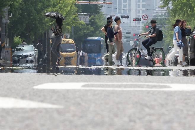 22일 오후 서울 영등포구 여의도공원 인근 도로에서 지열에 의한 아지랑이가 피어오르고 있다. 연합뉴스