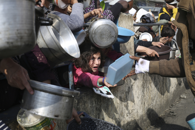가자지구의 팔레스타인 시민들이 음식 배급을 타기 손을 벌리고 있는 모습/AP연합뉴스