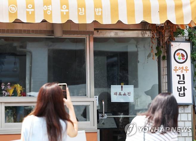 우영우 김밥 인증샷 '찰칵' (수원=연합뉴스) 2022년 8월 4일 오전 드라마 '이상한 변호사 우영우' 촬영지인 경기도 수원시 팔달구 행궁동의 한 식당 앞에서 시민들이 사진을 찍고 있다. [연합뉴스 자료사진]