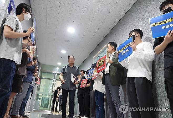 전북대 의대 교수 및 학생들 '학칙 개정 반대' (전주=연합뉴스) 나보배 기자 = 의대 증원을 담은 학칙 개정을 위한 전북대학교 교수평의회가 열린 22일, 의대 교수 및 학생들이 대학 본부 현관 앞에서 손팻말을 들고 의대 증원 반대를 촉구하고 있다. 2024.5.22 warm@yna.co.kr