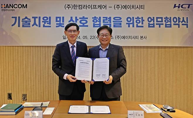 이달 22일 경기 이천 HCT 본사에서 김선영 한컴라이프케어 대표와 허봉재 에이치시티 대표가 기술·인적 교류 등 내용을 담은 업무협약(MOU)을 체결했다.(한컴라이프케어 제공)