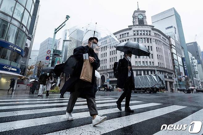 22일 겨울비 내리는 일본 도쿄 긴자 거리에 사람들이 우산을 쓰고 걸어가고 있다. 2022.12.22 ⓒ AFP=뉴스1 ⓒ News1 정윤미 기자