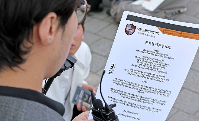 한 사직 전공의가 22일 서울 용산 대통령실 앞에서 윤석열 대통령에게 전달할 글을 읽고 있다. /뉴스1