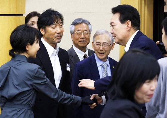 윤석열 대통령이 22일 오후 서울 서초구 대한민국 학술원에서 열린 대한민국 학술원 개원 70주년 기념식에 참석하며 가수 이문세씨 부부와 인사하고 있다. 대통령실사진기자단