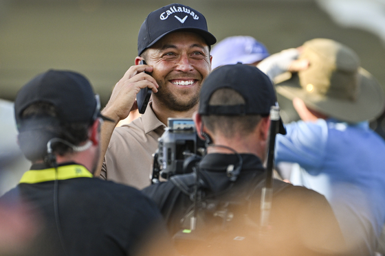 Xander Schauffele smiles as he speaks on his phone after his one-stroke victory in the final round of the 2024 PGA Championship at Valhalla Golf Club on May 19 in Louisville, Kentucky. [GETTY IMAGES]