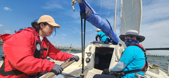 Mary, left, is super focused as she tries to wrangle the tiller. [SAILING PARADISE]