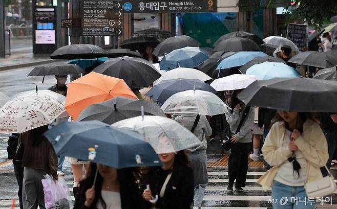 서울 마포구 홍대입구역 인근에서 시민들이 우산을 쓰고 걸어가고 있다./사진=뉴시스