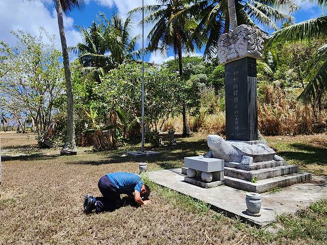 티니안 평화기원한국인위령비에 절하는 여행자