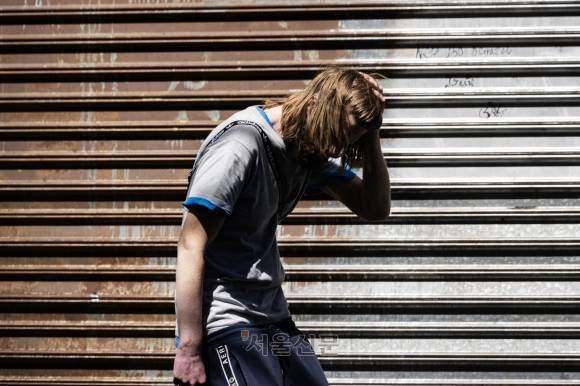 켄싱턴 거리에서 한 남성이 마약을 투약한 뒤 몸이 굳은 채 서 있다. 마약 중독으로 그의 손이 붉게 변해 있다.