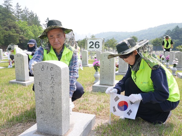 문상철 홍보실장(왼쪽)과 홍보실 직원이 현충원 묘역 정화활동을 하고 있다. ⓒ농협