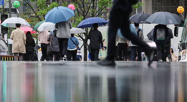 서울 종로구 광화문광장에서 우산을 쓴 시민들이 발걸음을 옮기고 있다. /뉴스1