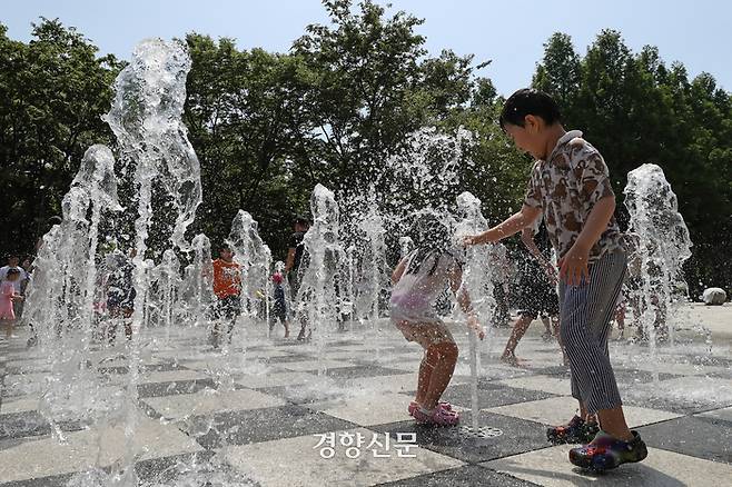 낮 기온이 30도 안팎으로 오르며 초여름 날씨가 이어진 지난 19일 서울 성동구 서울숲에 설치된 바닥분수에서 어린이들이 물놀이하며 더위를 식히고 있다. 조태형 기자