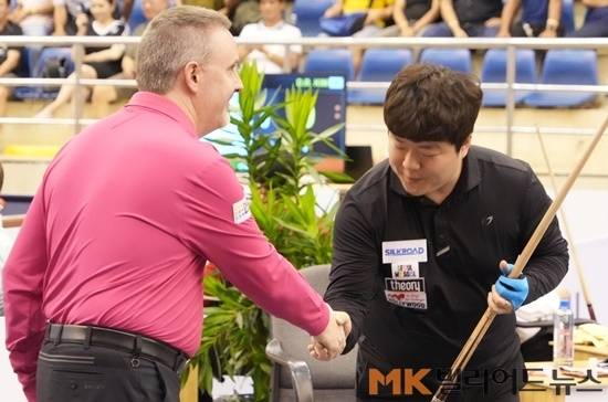 경기 전 악수를 나누고 있는 쿠드롱(왼쪽)과 조명우.