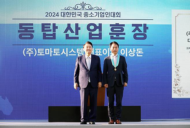 (왼쪽부터) 윤석열 대통령과 토마토시스템 이상돈 대표이사가 지난 23일  '2024 대한민국 중소기업인 대회'에서 동탑산업훈장을 받은 뒤 기념촬영을 하고 있다. /사진제공=토마토시스