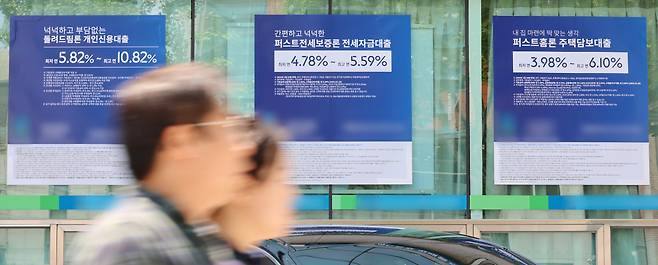 서울 한 시중은행 영업점의 대출 안내문을 앞을 시민이 지나가고 있다.[연합]