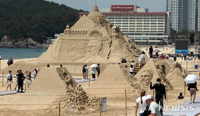 [부산=뉴시스] 하경민 기자 = '2024 해운대 모래축제' 개막일인 24일 부산 해운대해수욕장에서 시민과 관광객들이 다양한 모래조각 작품을 둘러보고 있다. 27일까지 열리는 이번 축제는 '세계 미술관 여행'을 주제로 세계적인 모래작가 12명이 만든 총 20개 작품을 전시하며, 이들 모래작품은 축제가 끝난 이후에도 6월9일까지 그대로 전시될 예정이다. 2024.05.24. yulnetphoto@newsis.com