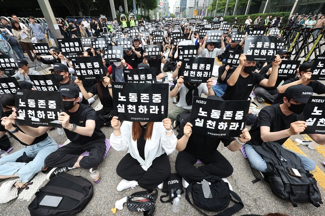 삼성전자 노동조합 조합원들이 24일 오후 서울 강남구 삼성전자 사옥 앞에서 노동조합과의 교섭을 촉구하는 손팻말을 들고 있다. 연합뉴스