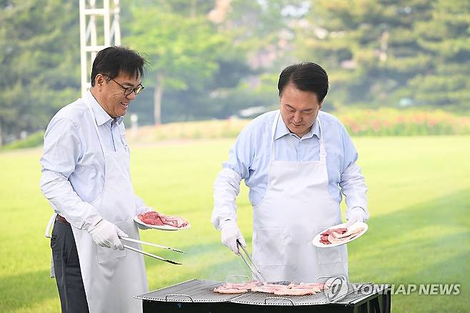 대통령의 저녁 초대, 앞치마 입은 윤석열 대통령 (서울=연합뉴스) 홍해인 기자 = 윤석열 대통령이 24일 서울 용산 대통령실 청사 잔디마당에서 열린‘대통령의 저녁 초대' 출입기자단 초청 만찬 간담회에서 정진석 비서실장과 함께 고기를 굽고 있다. 2024.5.24 [대통령실 제공. 재판매 및 DB 금지] hihong@yna.co.kr