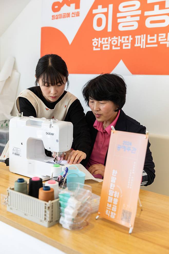 신효마을의 패브릭 공방인 ‘히읗공방’에서 홍지원 대표(왼쪽)가 재봉틀 다루는 방법을 교육하고 있다. 이수현 제공