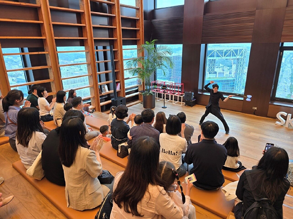 25일 SK서린빌딩에 열린 구성원 가족 초청행사 '오픈하우스'에 참여한 SK이노베이션 구성원과 가족들이 서커스를 관람하고 있다. [사진=SK이노베이션]