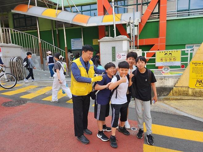 창원 용남초등학교에서 배움터지킴이로 근무하는 한길수씨가 등교하는 아이들과 인사를 나누고 있다.