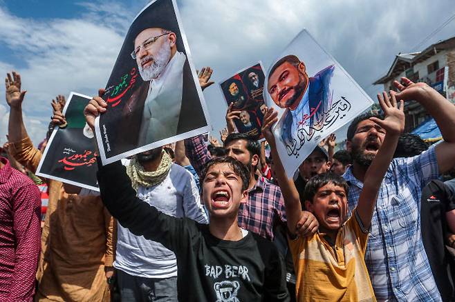 24일(현지시간) 이란 스리나가르 외곽에서 열린 연대 행진에서 헬기 추락으로 사망한 이란의 고(故) 에브라힘 라이시 대통령에 대한 애도를 표하며 구호를 외치고 있다.