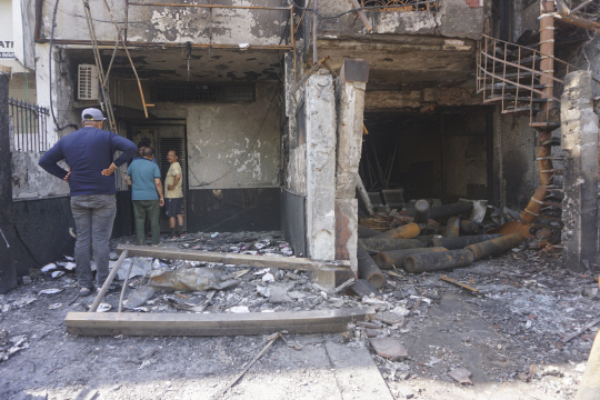 26일(현지시간) 인도 델리의 한 영유아 병원에서 사람들이 불에 탄 건물을 보고 있다.    [델리 AP=연합뉴스]