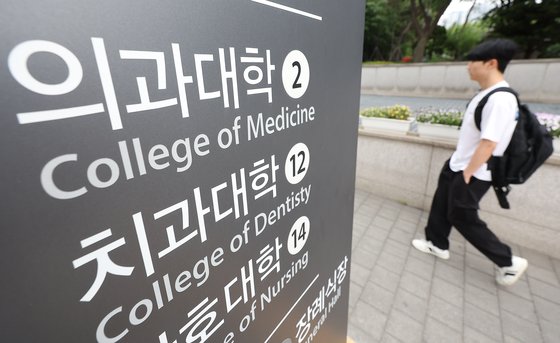 27년 만의 의대 입학정원 증원이 확정된 24일 시민들이 서울 시내 한 의과대학 인근을 지나고 있다. 연합뉴스
