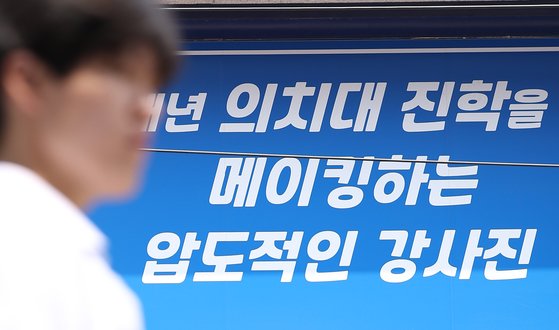 27년 만의 의대 입학정원 증원이 확정된 24일 서울 시내 한 학원 건물에 의대 입시 홍보물이 붙어 있다. 한국대학교육협의회는 이날 대입전형위원회를 열고 각 대학이 제출한 2025학년도 대입전형 시행계획 변경 사항을 심의·확정했다. 연합뉴스