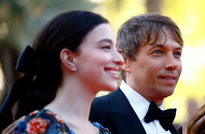 제77회 칸영화제에서 영화 ‘아노라’로 황금종려상을 수상한 션 베이커 감독(오른쪽)과 성매매 여성 아노라(약칭 ‘애니’) 역을 맡은 주연배우 밀키 매디슨이 시상식장으로 들어서고 있다. [로이터 연합뉴스]