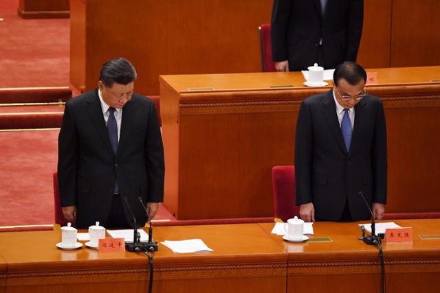 2020년 10월 23일 시진핑(왼쪽) 중국 국가주석과 리커창 당시 국무원 총리가 항미원조 전쟁 70주년 기념식이 열린 베이징 인민대회당에서 전사자들을 위한 묵념을 하고 있다. 베이징=AFP 연합뉴스