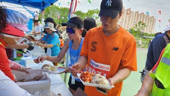 제20회 금천구청장배 건강달리기 대회 참가자들이 수육과 두부, 김치 등을 받고 있는 모습. 김서원 기자
