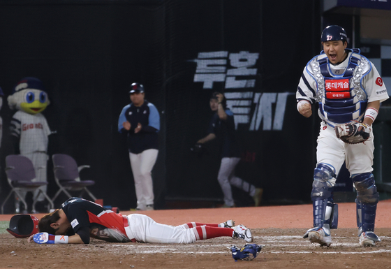 With bases loaded and one out at the top of the ninth inning during a game against the Lotte Giants, Kia Tigers' Park Jung-woo, left, is tagged out at home plate at Sajik Baseball Stadium in Busan on May 22. [YONHAP]