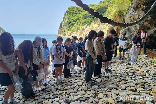문화기행단 학생들이 백제 무령왕 출생지로 알려진 가카라시마 섬 동굴 앞에서 헌화와 묵념을 하고 있다. 사진=홍석원 기자