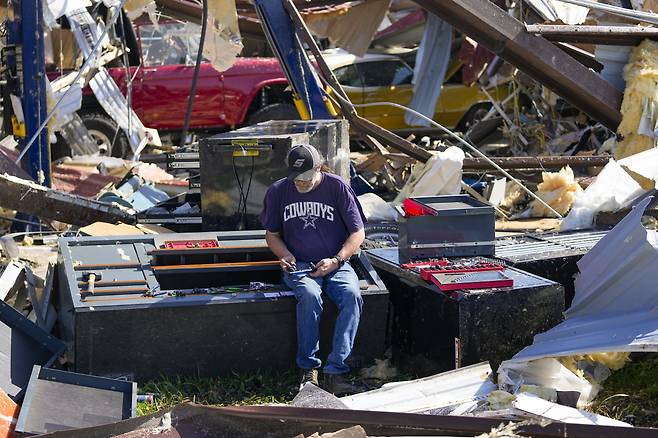 26일(현지시간) 미국 텍사스 밸리뷰에서 한 보디샵 직원이 토네이도가 지나간 현장에서 잔해들을 정리하고 있다. [AP]