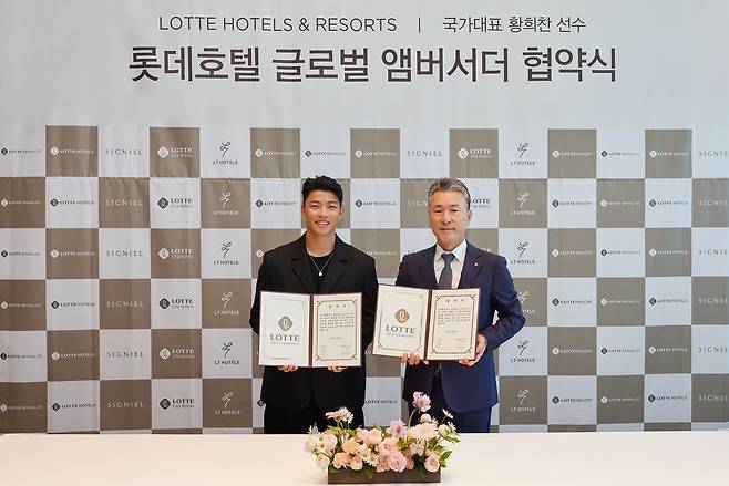 롯데호텔앤리조트 김태홍 대표이사(오른쪽)와 황희찬 선수가 롯데호텔 글로벌 앰버서더 협약식에서 포즈를 취하고 있다.(롯데호텔앤리조트 제공).