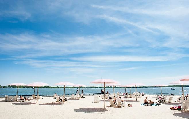 캐나다 토론토 슈가비치(Sugar Beach) 해변에서 책을 읽거나 모래사장에서 놀거나 호수에서 보트를 타며 사람들이 휴가를 즐기고 있다. 2025.05. 27/ (출처: 캐나다 관관청)