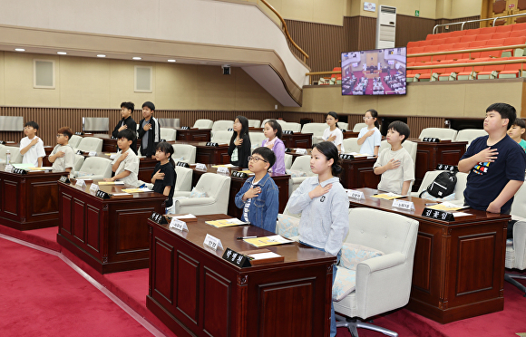 28일 충북도의회 본회의장에서 104회 청소년 의회교실에 참여한 충주 산척초등학교 학생들이 국민의례를 하고 있다. [사진=충북도의회]