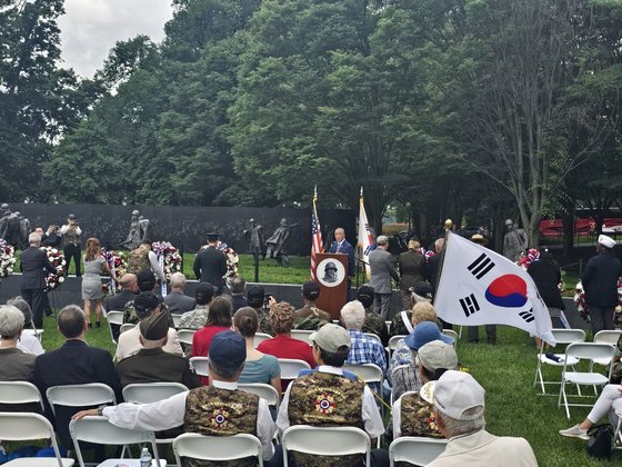 미국 메모리얼 데이인 27일(현지시간) 워싱턴 DC 한국전참전기념공원에서 열린 ‘한국전 참전 추모식’에서 스티브 리(가운데 연단에 선 이) 한국전참전용사기념재단 회장의 구호에 맞춰 참석자들이 헌화 행사를 진행하고 있다. 워싱턴=김형구 특파원