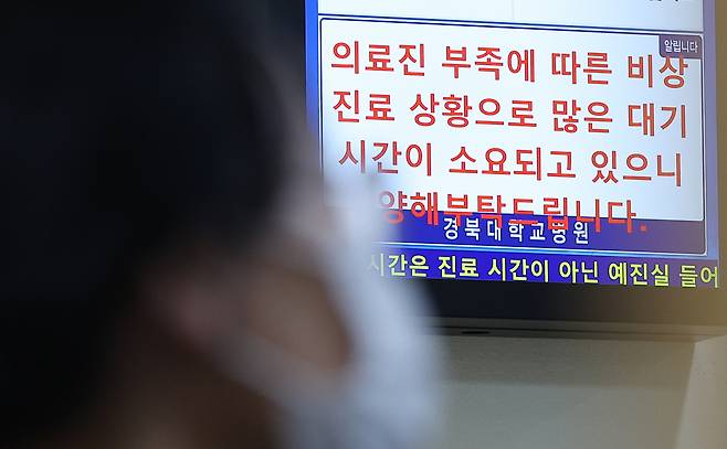 A notice is displayed on a hospital screen informing patients that they may experience longer waiting times due to a shortage of medical personnel. (Yonhap)