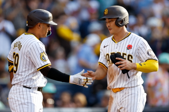 BASEBALL-MLB-SD-MIA/ - May 27, 2024; San Diego, California, USA; San Diego Padres shortstop Ha-Seong Kim (7) celebrates with San Diego Padres designated hitter Donovan Solano (39) after scoring a run in the seventh inning against the Miami Marlins at Petco Park. Mandatory Credit: David Frerker-USA TODAY Sports