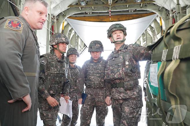 지상작전사령관 손식 대장이 29일 강원도·경기도 일대에서 진행된 한미연합합동 공중재보급훈련에서 미 공군 수송기 기장 라이언 존스 소령을 비롯한 훈련 관계자들과 이야기를 나누고 있다. (지상작전사령부 제공) 2024.5.29/sbtm1 ⓒ News1 한귀섭 기자