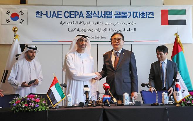 정인교 산업부 통상교섭본부장과 타니 빈 아흐메드 알 제유디 UAE 경제부 대외무역특임장관이 29일 오후 서울 종로구 포시즌스호텔에서 열린 한-UAE 포괄적경제동반자협정(CEPA) 정식 서명 공동 기자회견에서 악수하고 있다. 연합뉴스