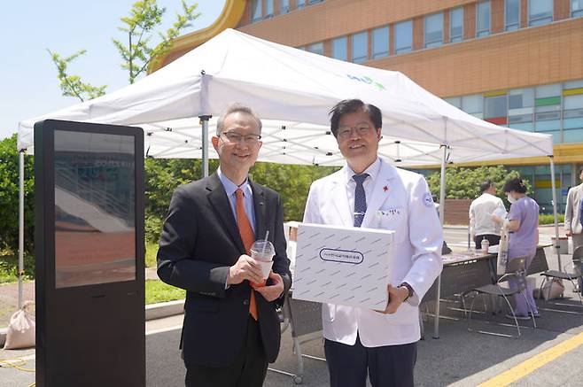 [양산=뉴시스] 오풍연(왼쪽) 이사장과 이상돈 병원장이 한국교직원공제회에서 준비한 상품 들고 기념촬영을 하고 있다. (사진=양산시 제공) 2024.05.30. photo@newsis.com *재판매 및 DB 금지