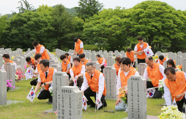 한화그룹 충청지역 봉사단이 6월 호국보훈의 달을 앞두고 30일 국립대전현충원에서 태극기 교체 등 봉사활동을 하고 있다. 사진제공=한화그룹